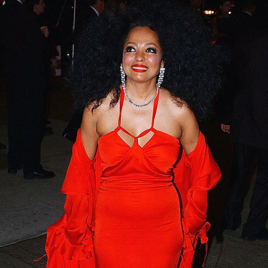 Diana ross wearing a  red maxi dress and matching red lipstcik 