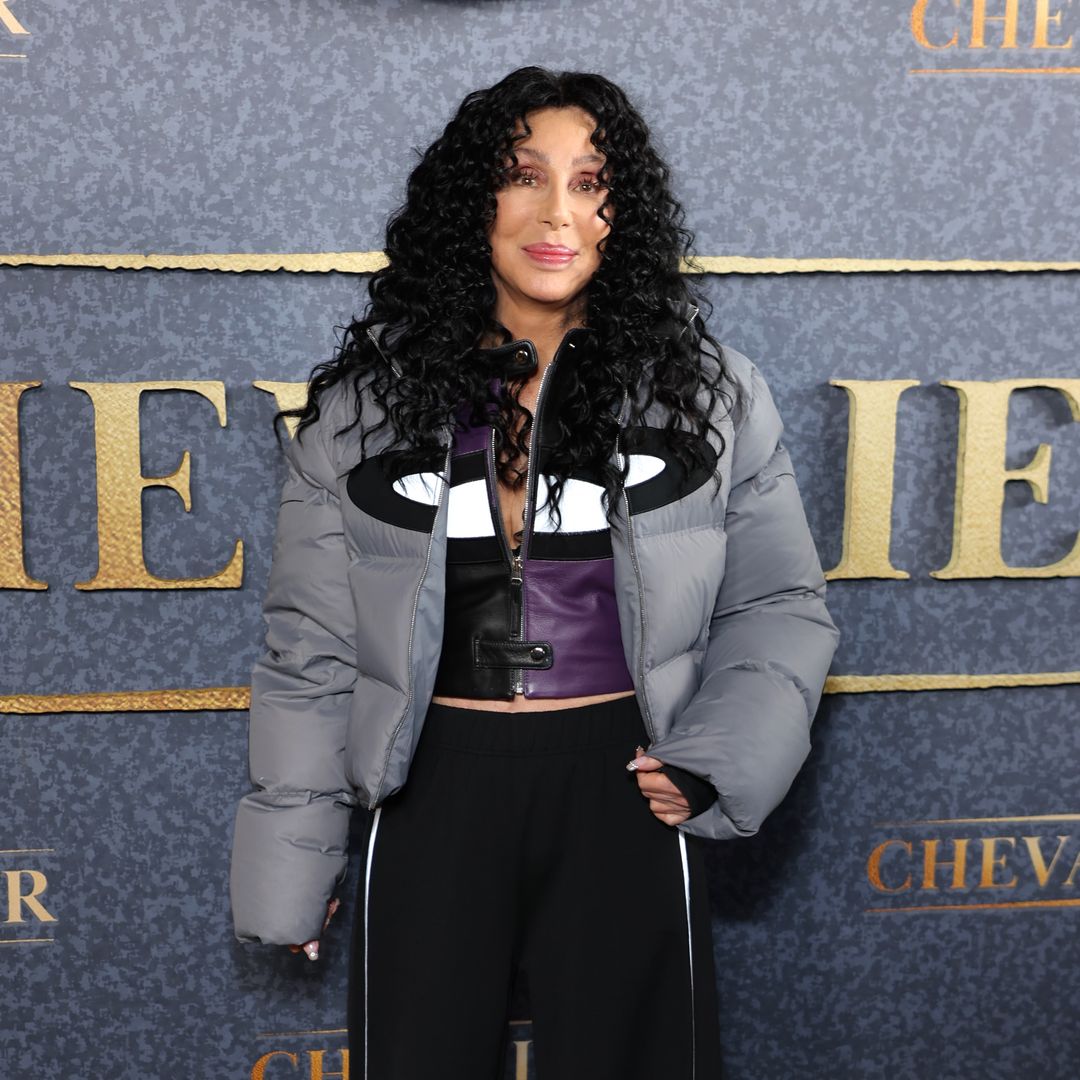 Cher looks unreal in ab-baring leather waistcoat and retro satin pants