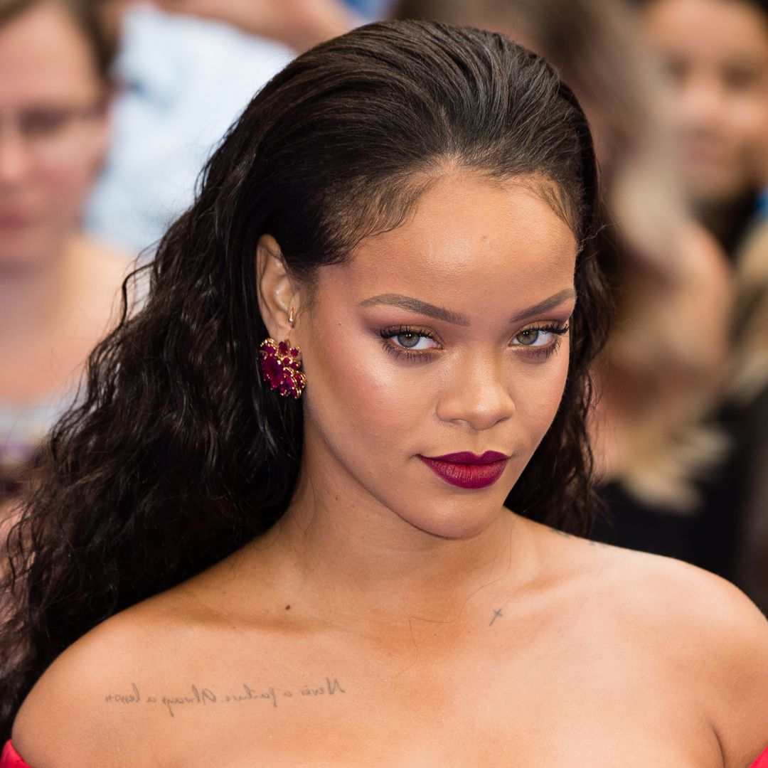 Rihanna wearing a red dress with her collarbone tattoo visible 