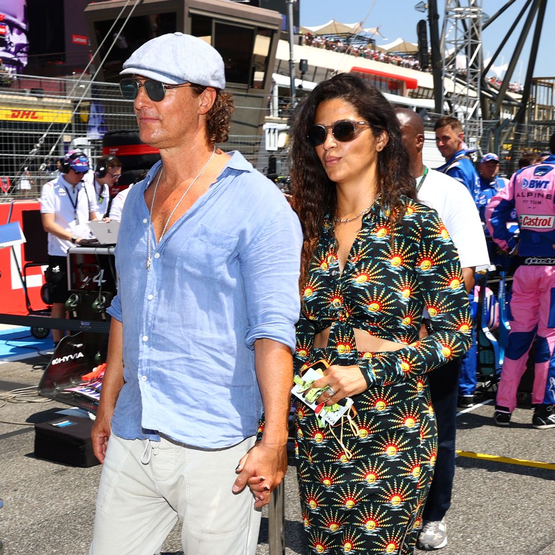 Matthew and Camila walking hand in hand at a grand prix event