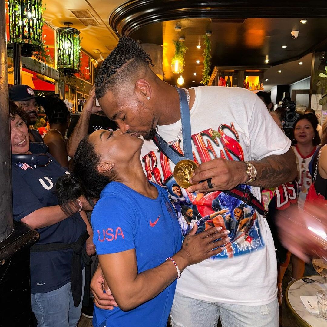 Simone Biles' husband Jonathan Owens proudly kisses his wife as she makes Olympic history