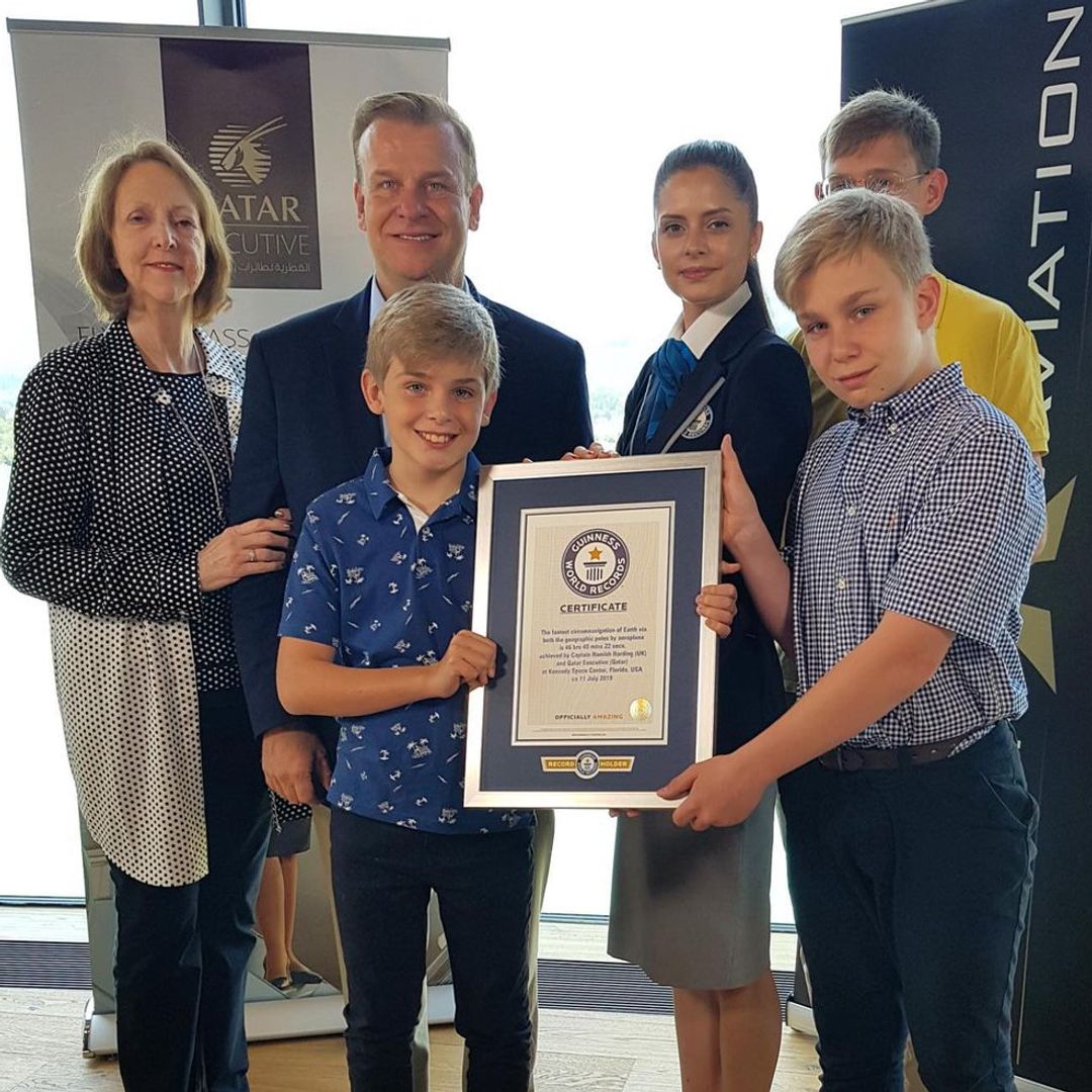 Hamish's sons holding a Guinness World Record certificate with their parents and two others behind them