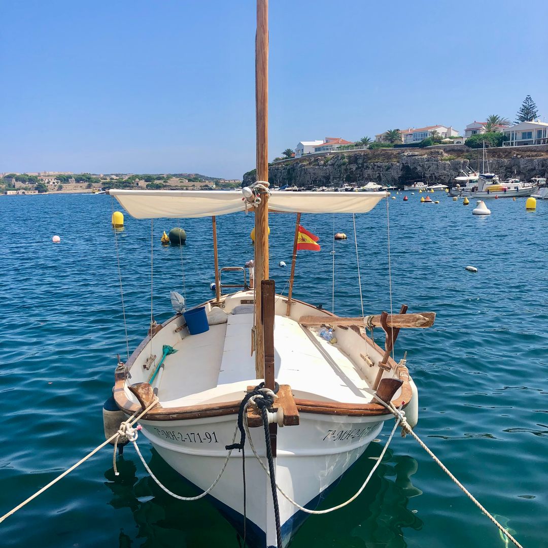 close up shot of boat floating on the water with landscape in the background
