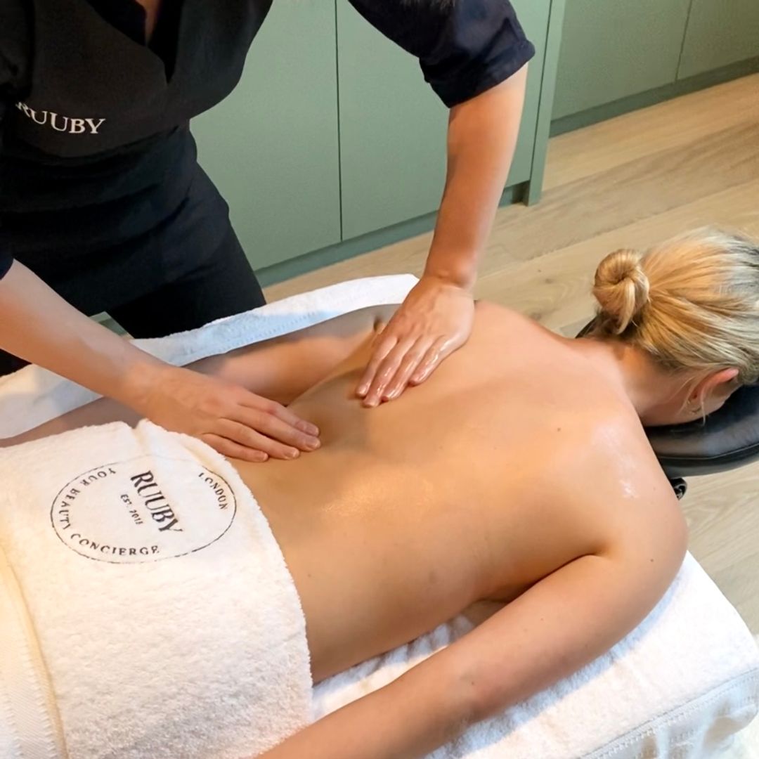 woman giving a massage to another woman in her own home