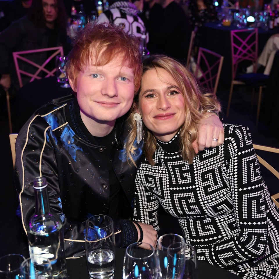 Ed e Cherry estavam sentados à mesa, sorrindo para a câmera, ele tem o braço em volta do ombro dela