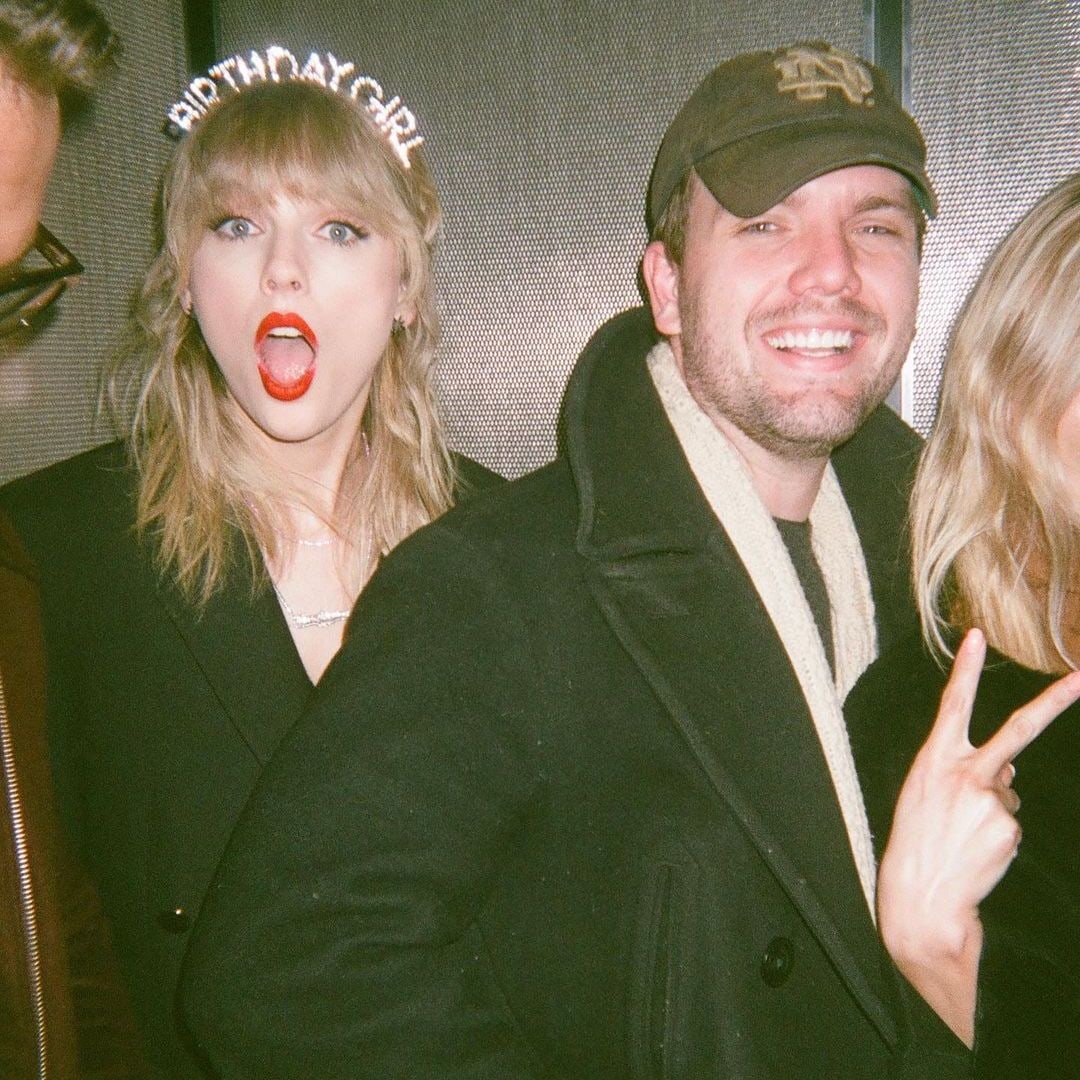 Taylor and Austin smiling and posing with others for a photo at a party
