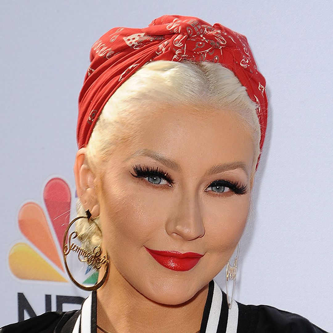 Christina Aguilera dons PVC coat to revisit iconic past outfits