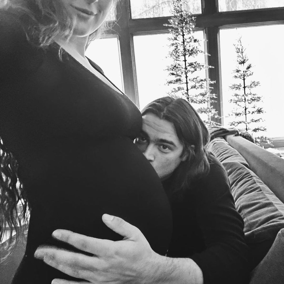 A black and white photo of Rumer's baby bump, with Derek kissing it