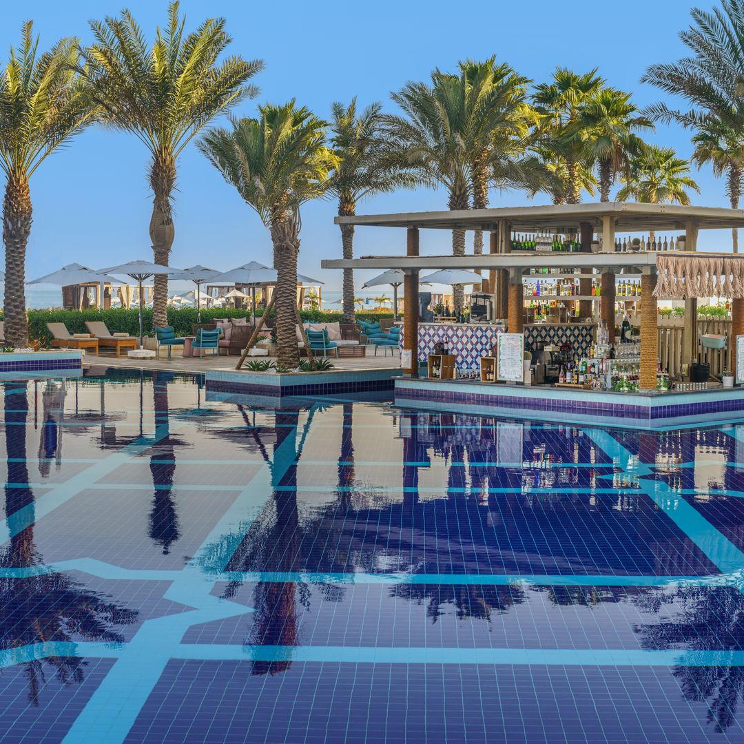 Pool bar with palm trees reflecting in water