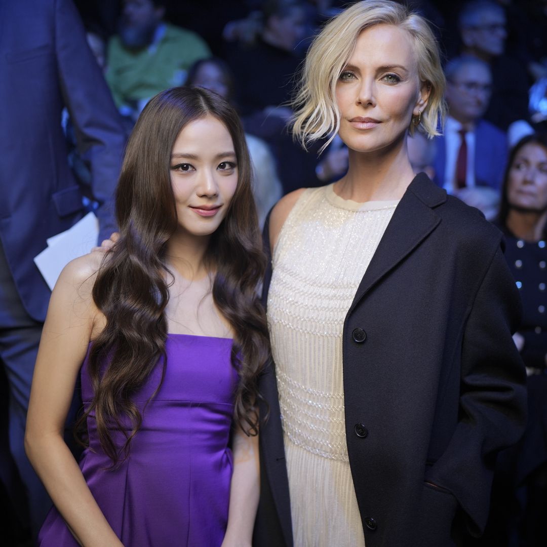 Charlize smiling with fellow Dior partner Jisoo