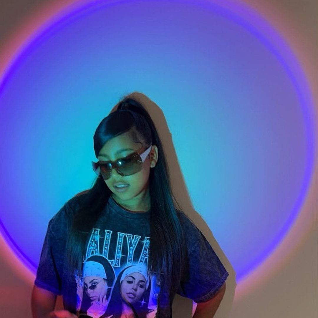 North West in sunglasses posing in a blue light