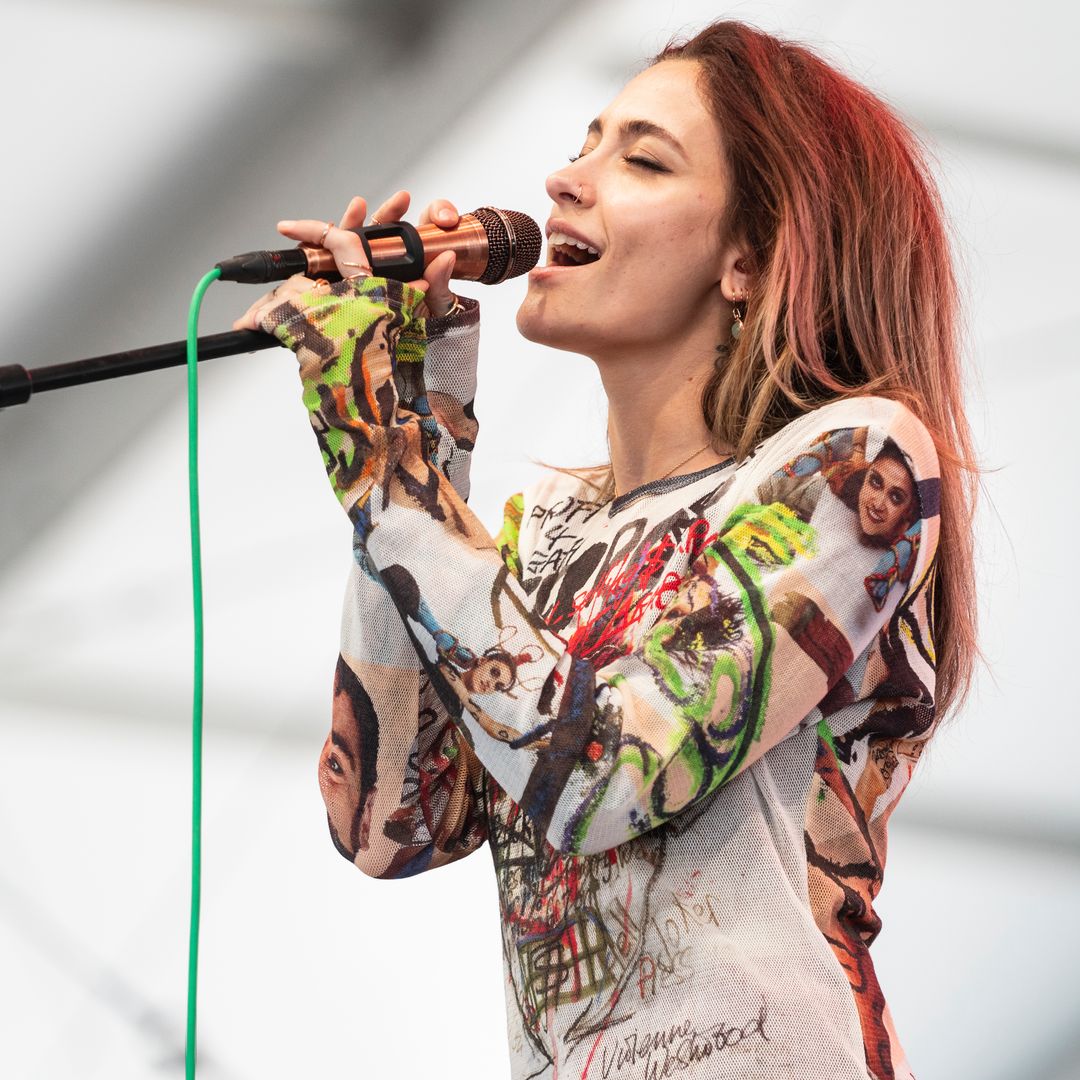 Paris Jackson performing on stage singing into a mic