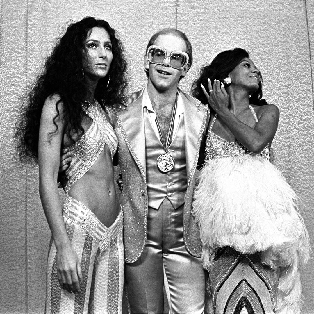 Cher, Elton John and Diana Ross dressed in glamorous outfits 