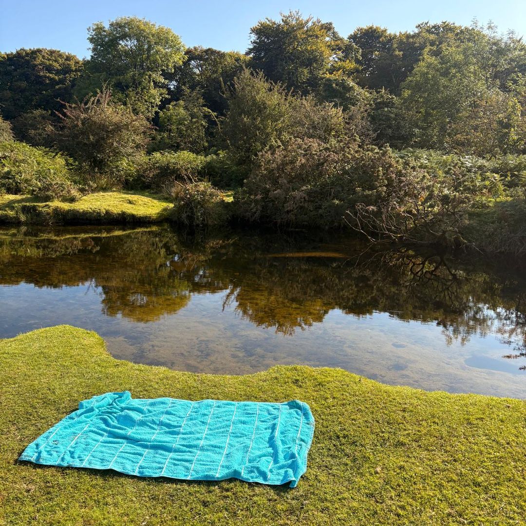 a river on Bodmin Moor with a towel on the grass nearby