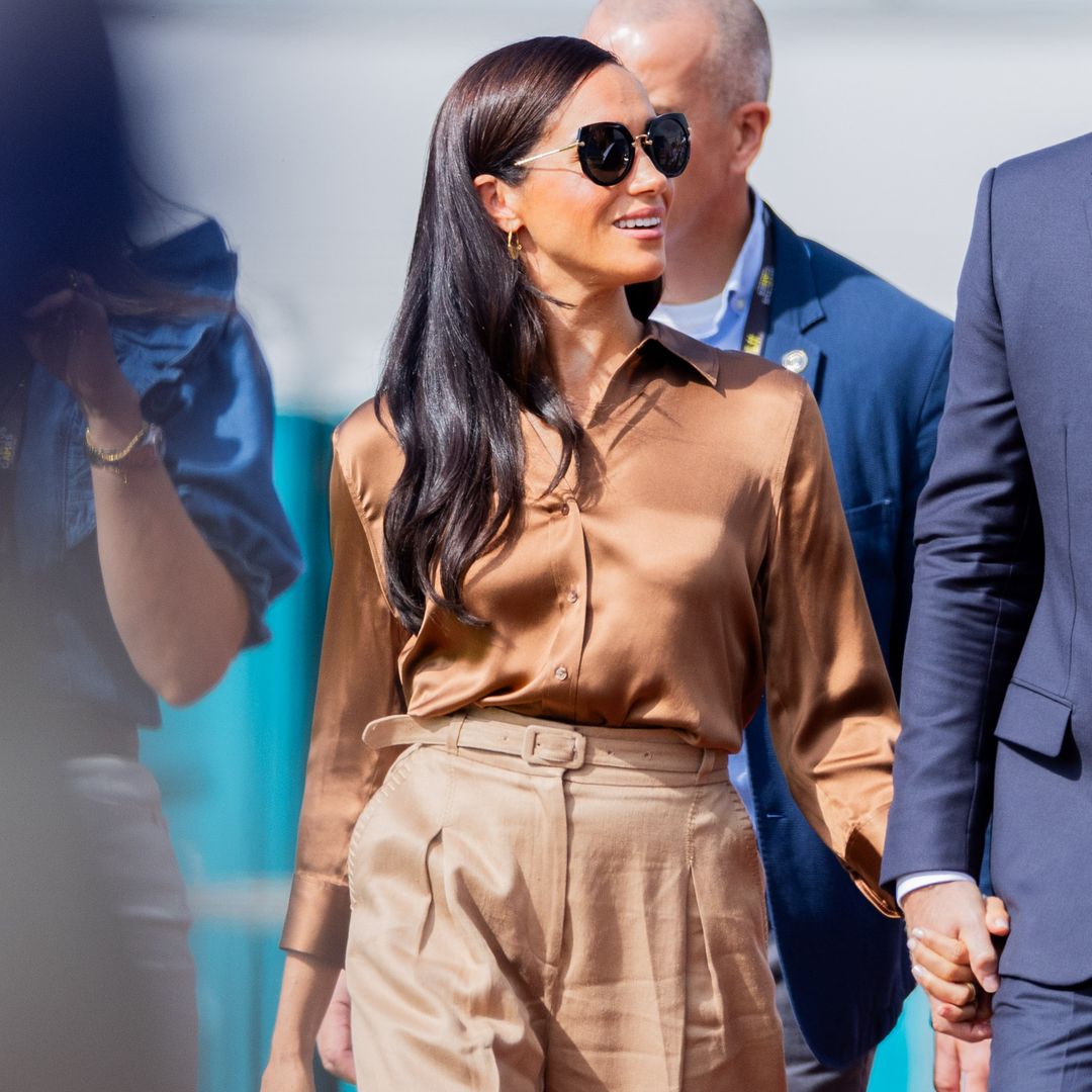 Meghan Markle is the queen of neutrals in belted trousers and silky caramel blouse