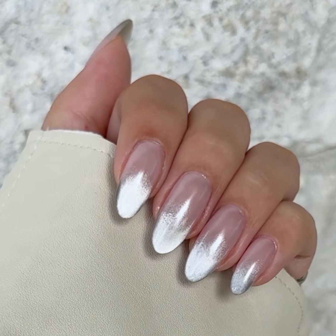 A hand showing off a silver cat eye manicure 