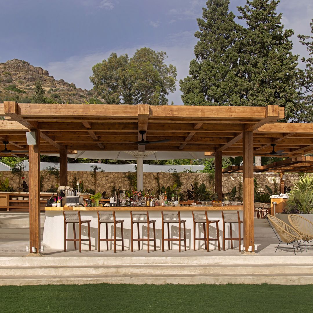 Bar en plein air de l'Avantgarde Refined Bodrum avec pergola en bois, sièges et jardins paysagers.