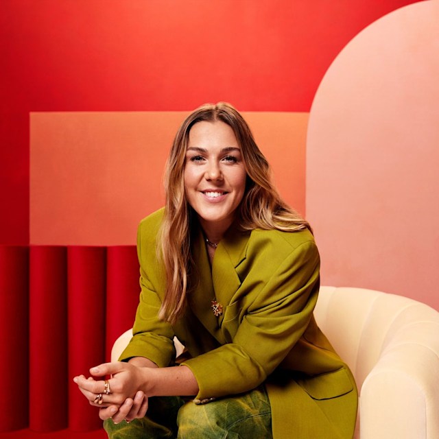 Mary Earps in green suit against red backdrop