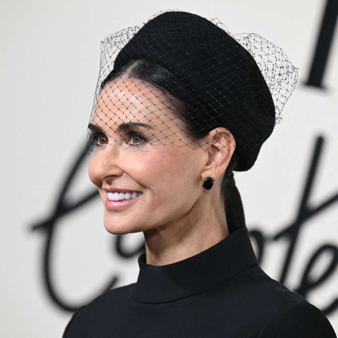 Demi Moore is a gothic beauty in waist-defining trousers and dramatic facial veil
