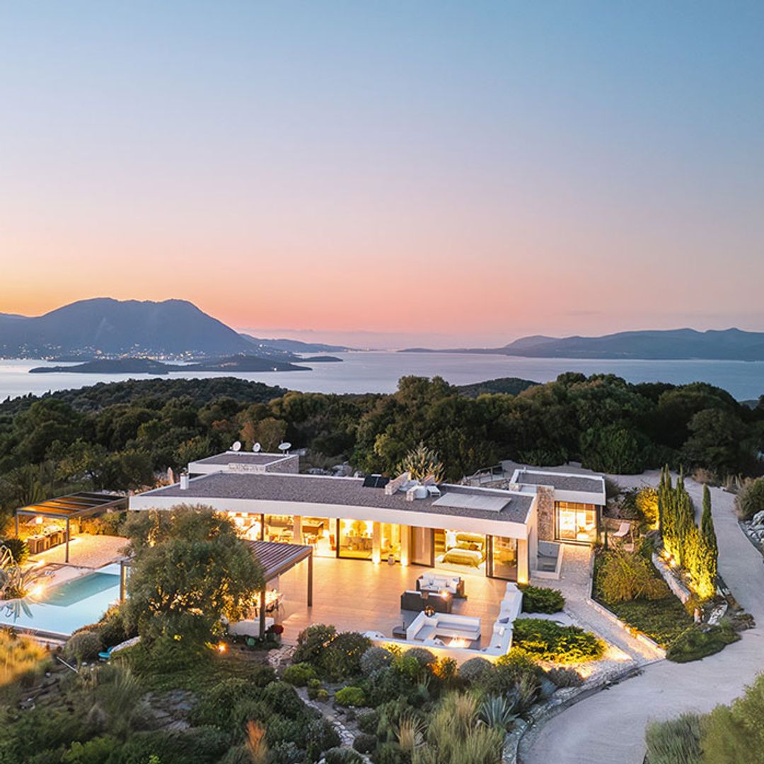 Aerial shot of villa on Greek island with sunset in the background