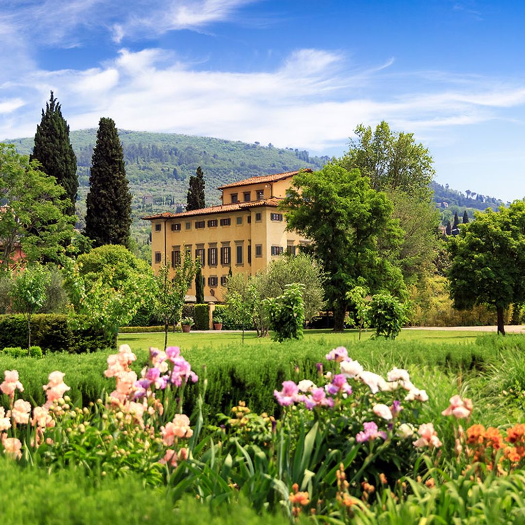 Villa in Tuscany with flowers and field in the foreground