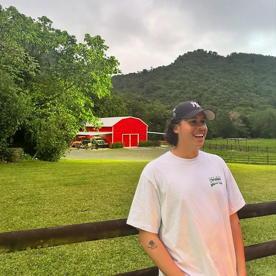 Bysael Martínez Ocasio captured smiling while posing for a photo near a farm, shared on Instagram