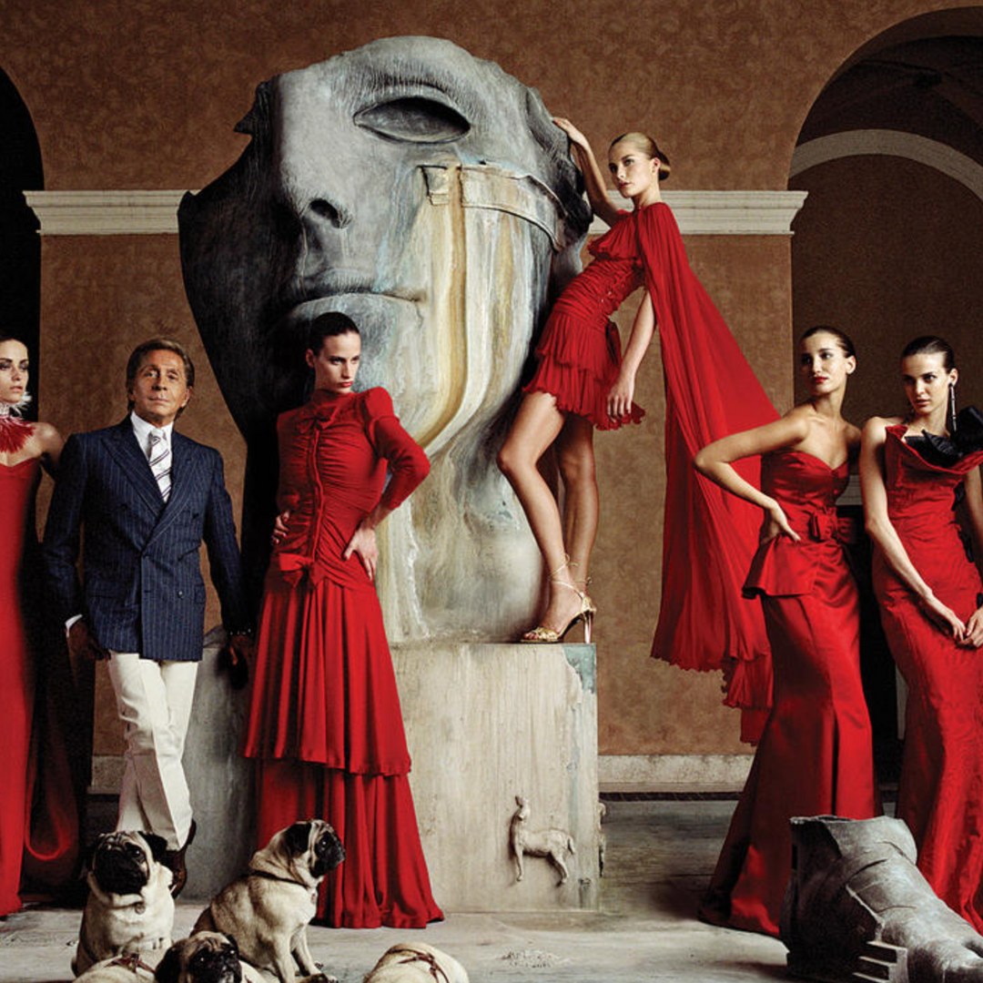 Valentino Garavani posing with just a few of his red hot creations