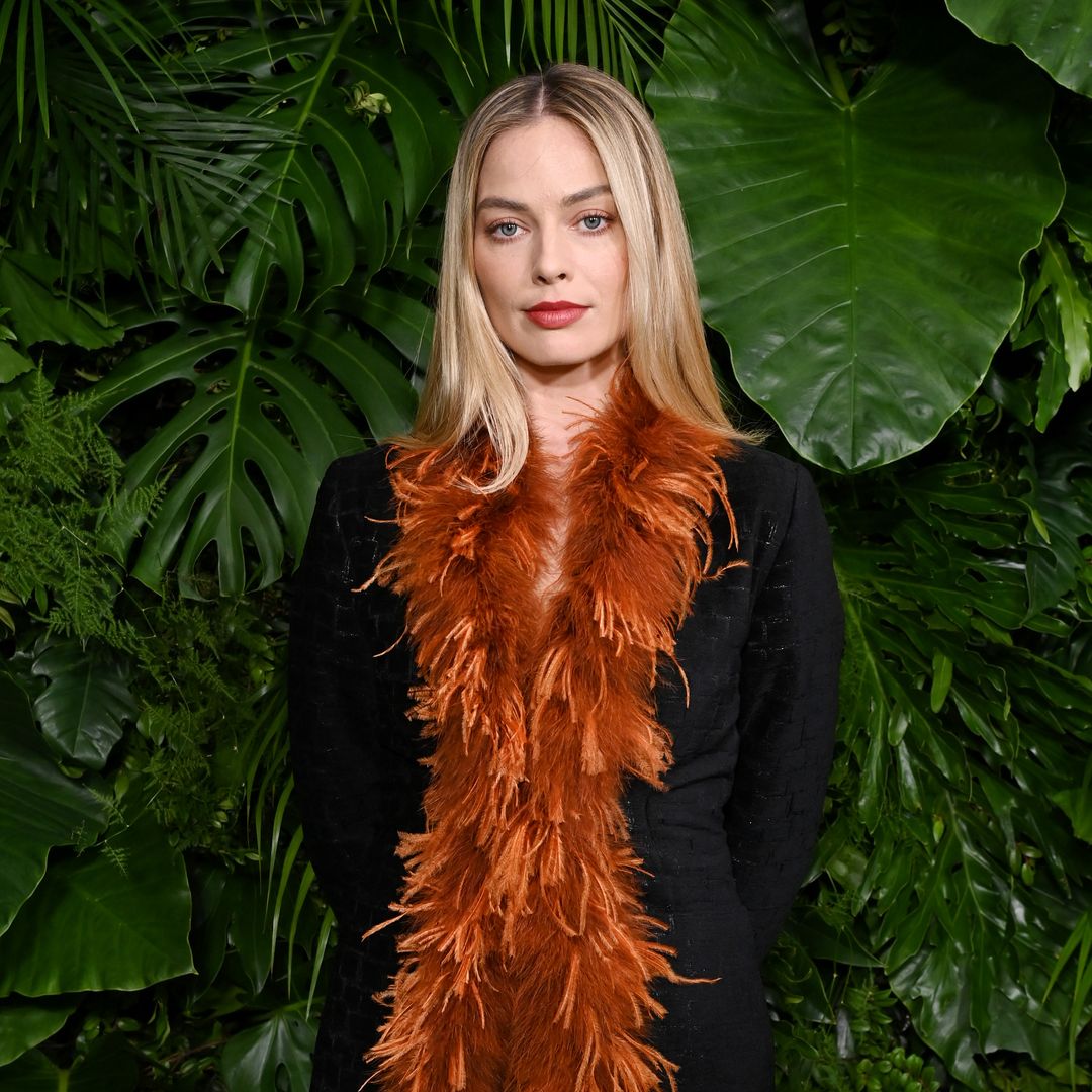 Margot Robbie rocks wild feathered mini dress and poker straight hair