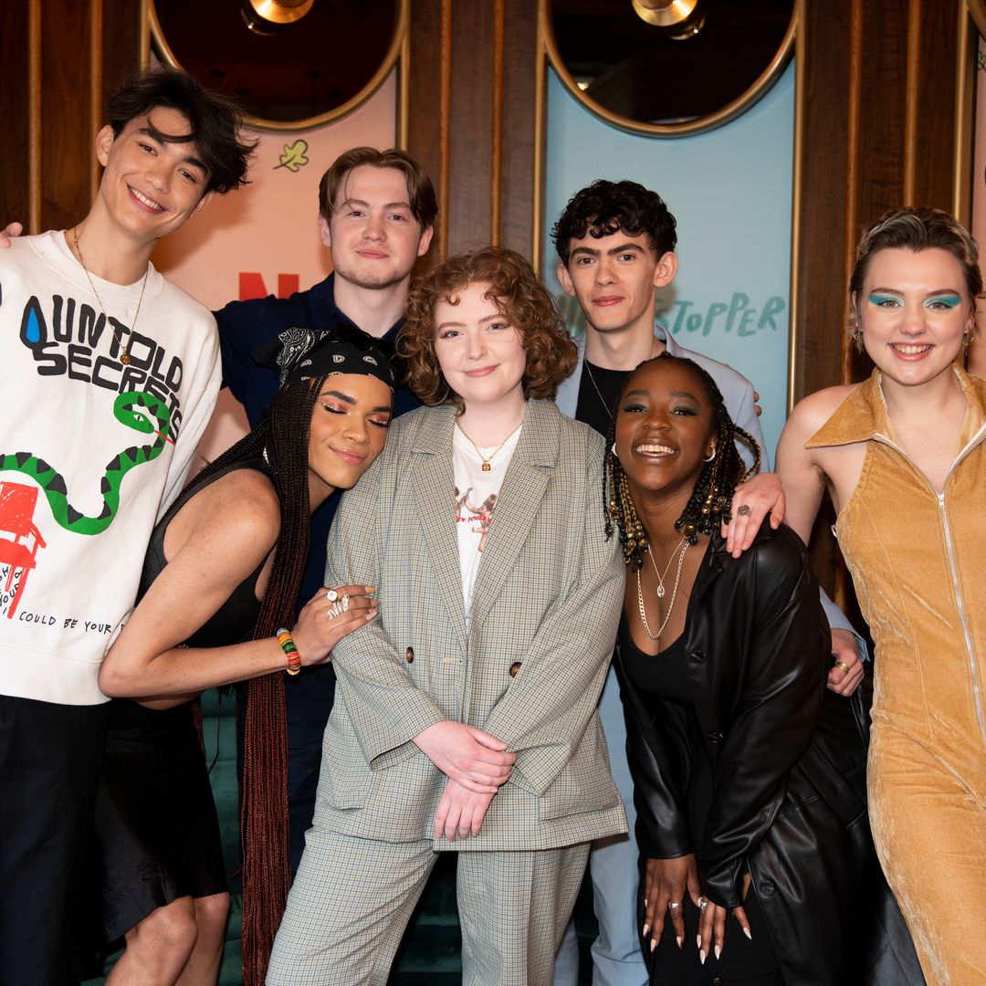 Alice and six of the show's main cast stood smiling at an exclusive Netflix event