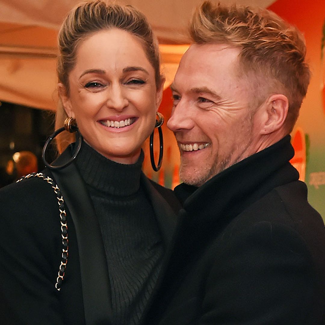Pregnant Storm Keating cradles blossoming baby bump in polo neck dress for family night out