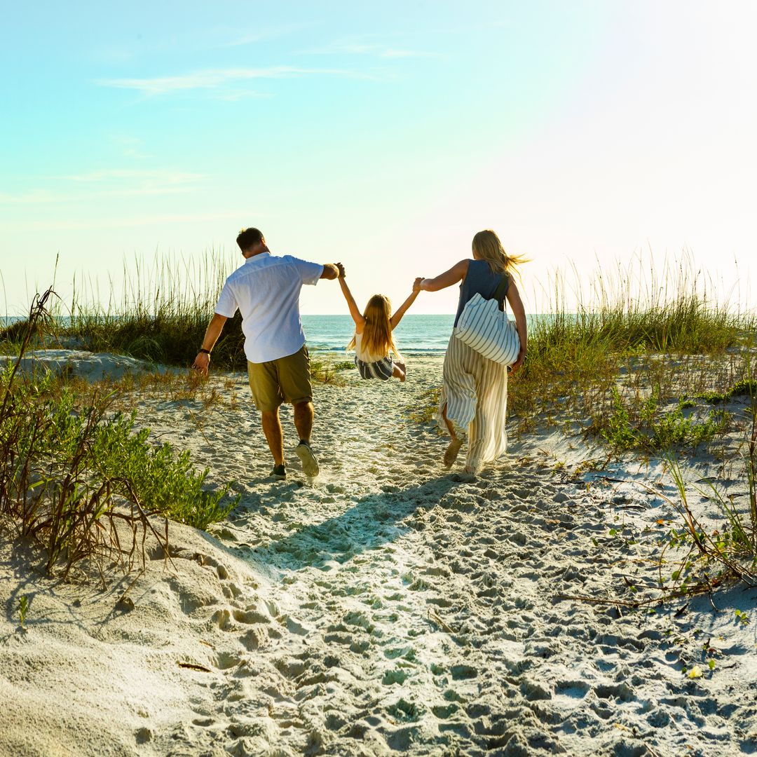 Couple walking with child on beach in Florida