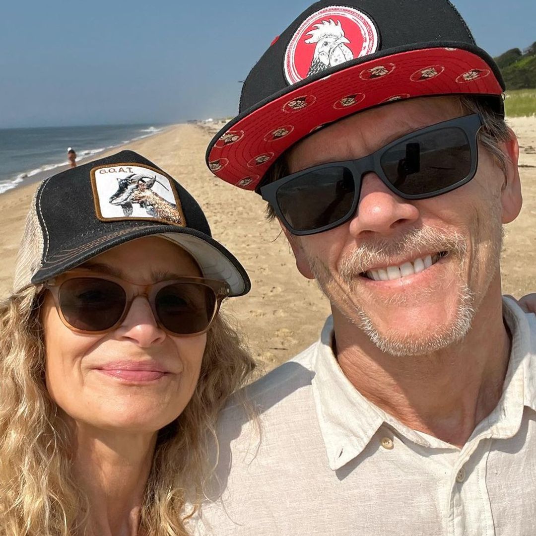Kyra and Kevin smiling at the beach both wearing sunglasses