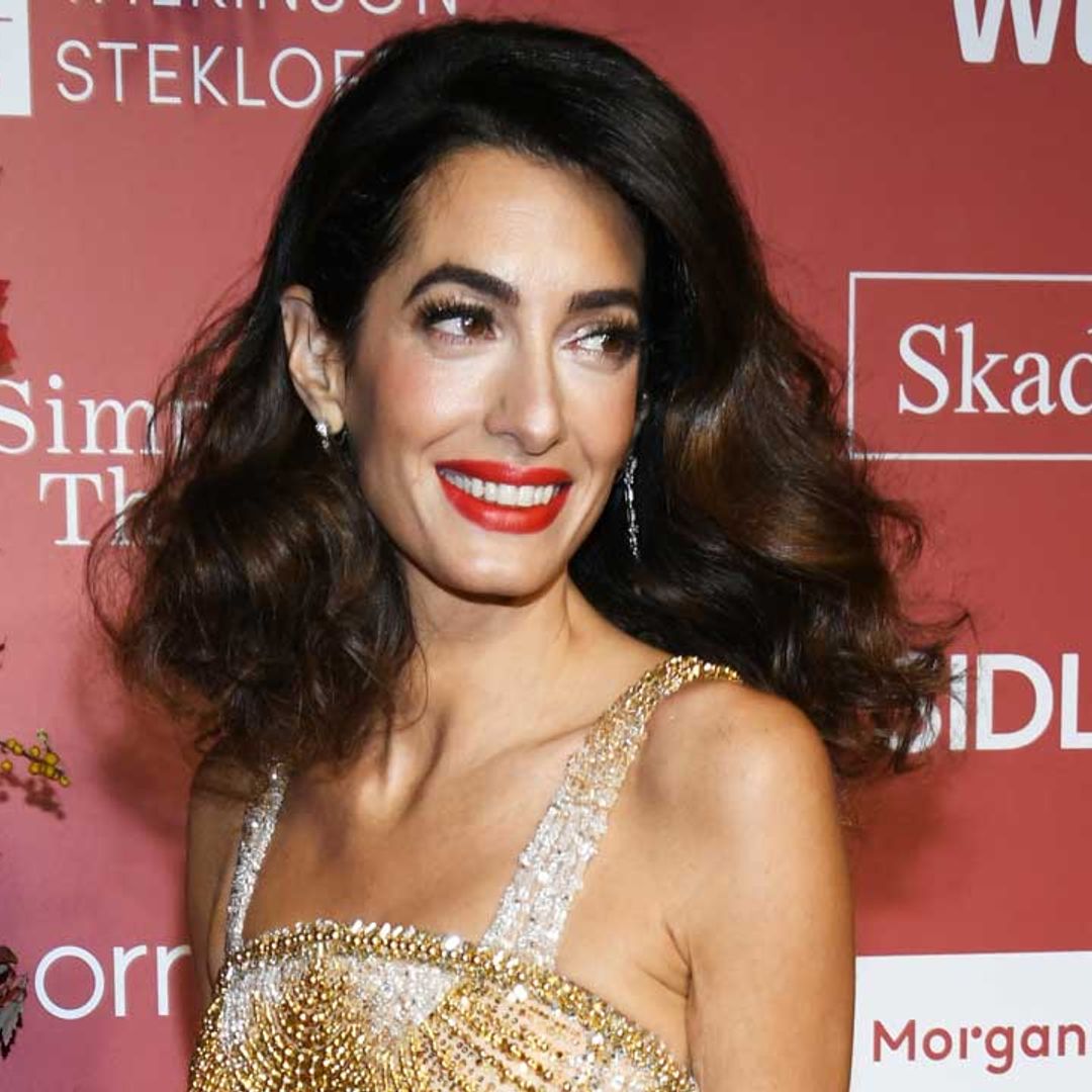 Amal Clooney dazzles in gold dress – and George can't take his eyes off her
