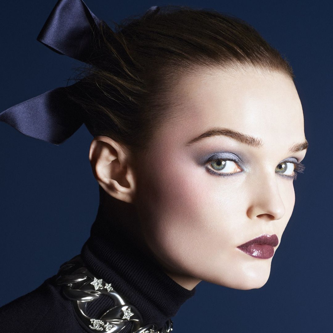 a model wearing blue eyeshadow and red glossy lipstick 