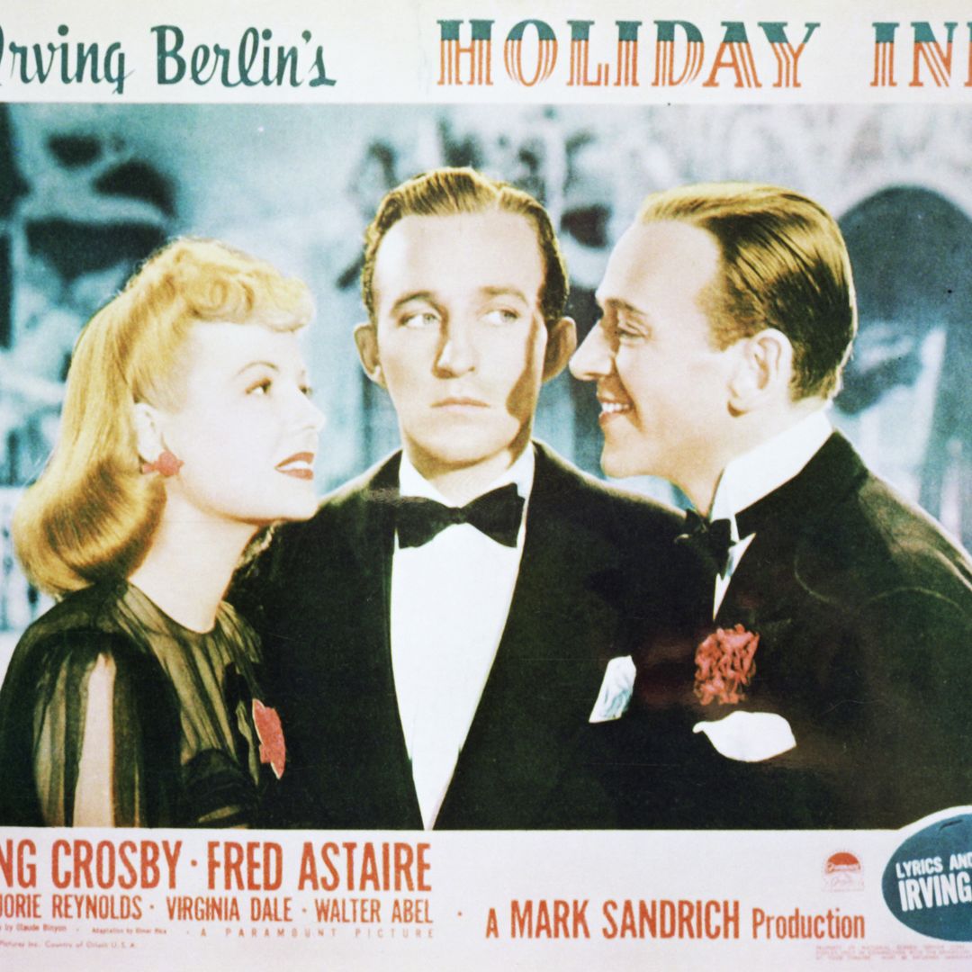A lobby card for Mark Sandrich's 1942 film musical 'Holiday Inn', starring (left to right) Marjorie Reynolds, Bing Crosby and Fred Astaire. 
