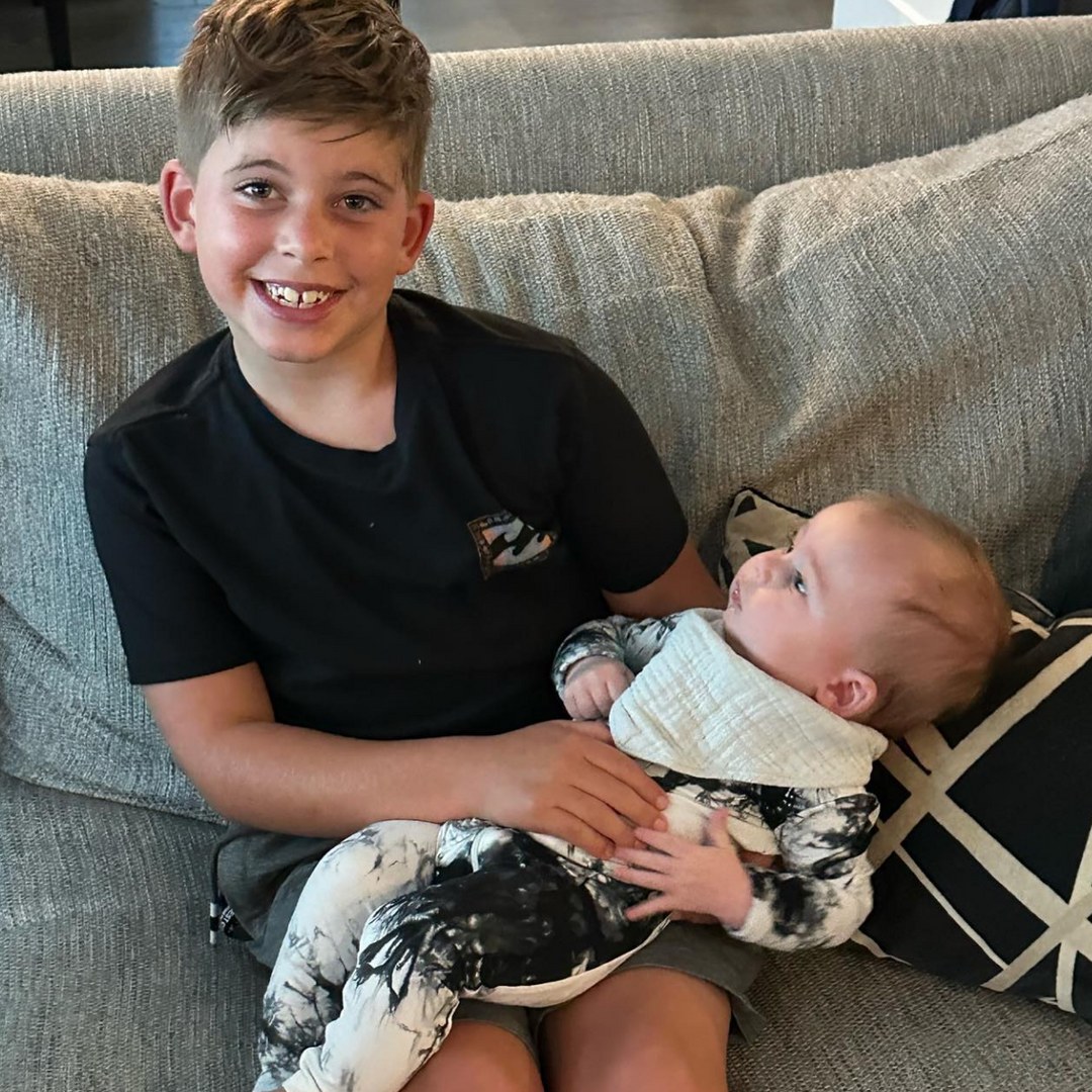 Photo shared by Heather Rae Young on Instagram August 2023 in a birthday tribute to her husband Tarek El Moussa's son with Christina Hall, Brayden, where he is pictured with his half-brother Tristan on his lap