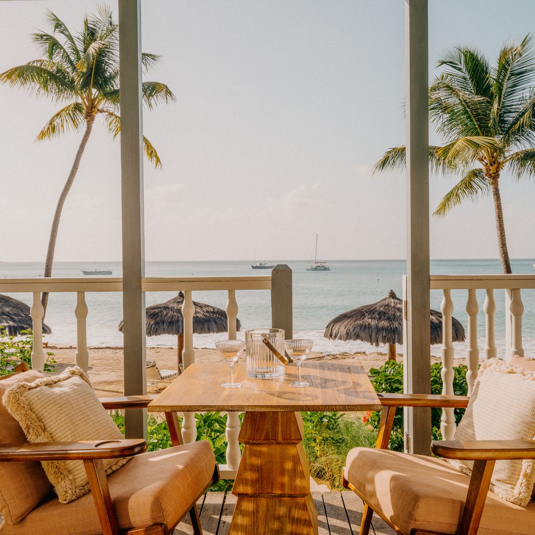 dining area outside hotel with ocean in the background