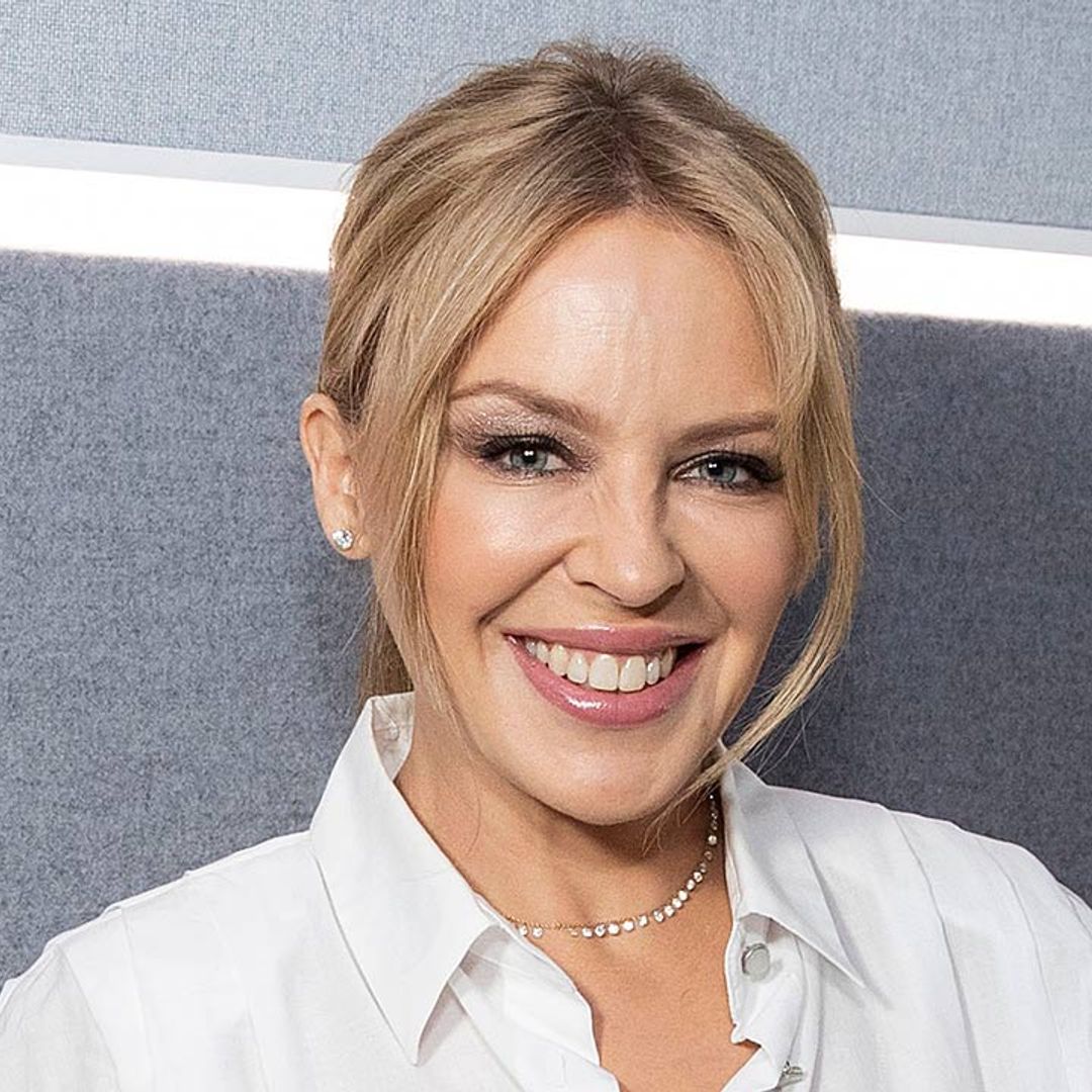 Kylie Minogue stuns in denim mini skirt and boyfriend's shirt following return to UK