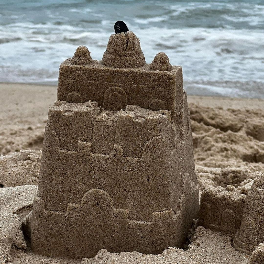 A sandcastle with the sea behind it