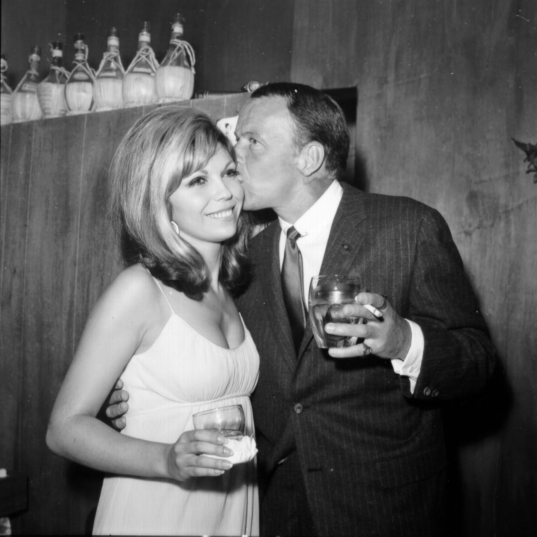 CIRCA 1967: O cantor pop Frank Sinatra desfruta de um coquetel em um evento com sua filha, a cantora Nancy Sinatra, por volta de 1967.
