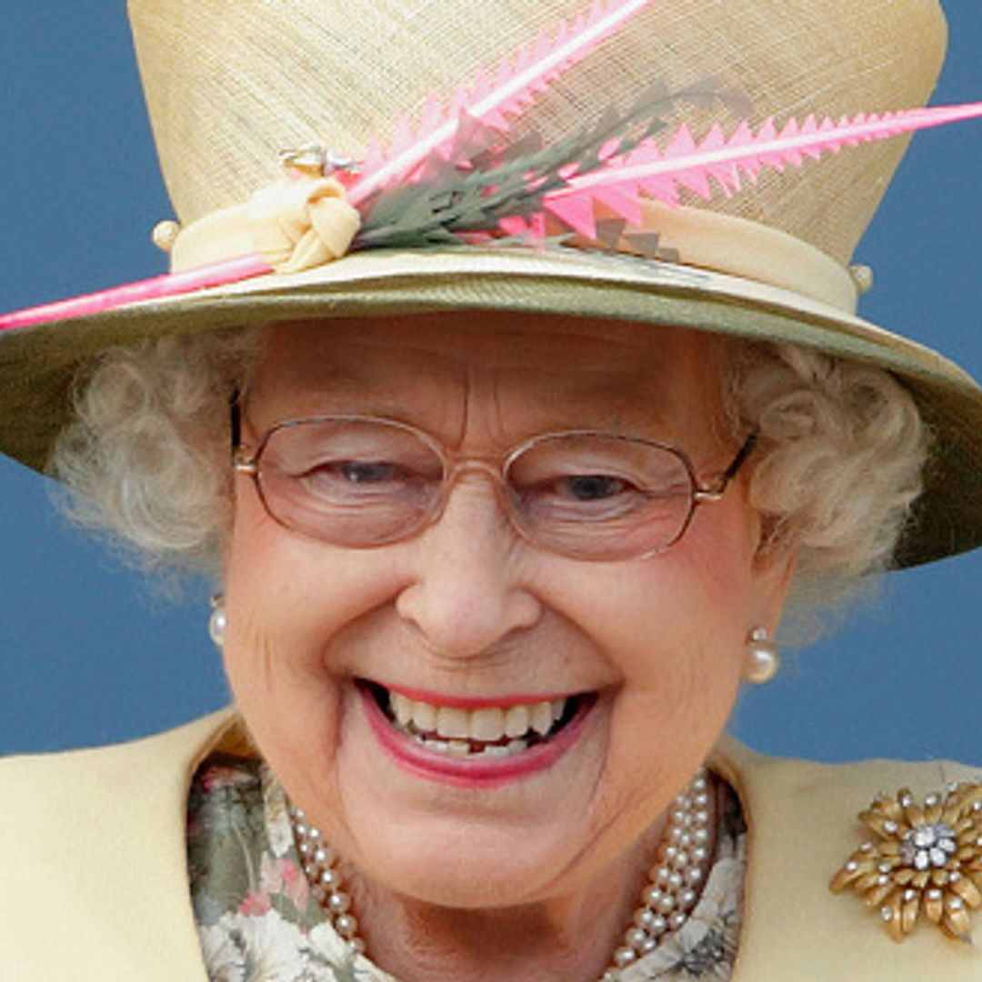 Queen Elizabeth shakes hands with polite young boy in top hat