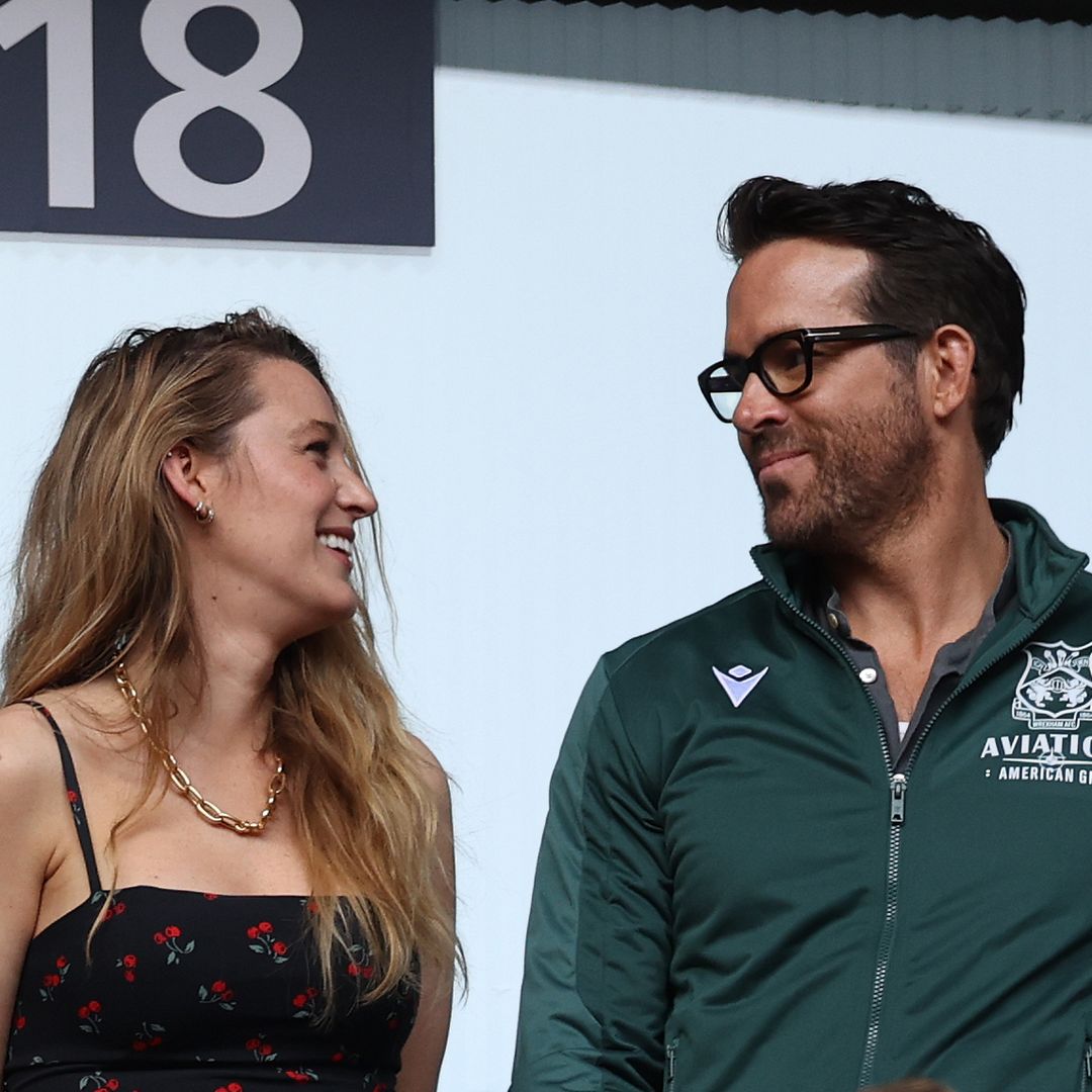 Ryan Reynolds and Blake Lively smiling at eachother while watching soccer