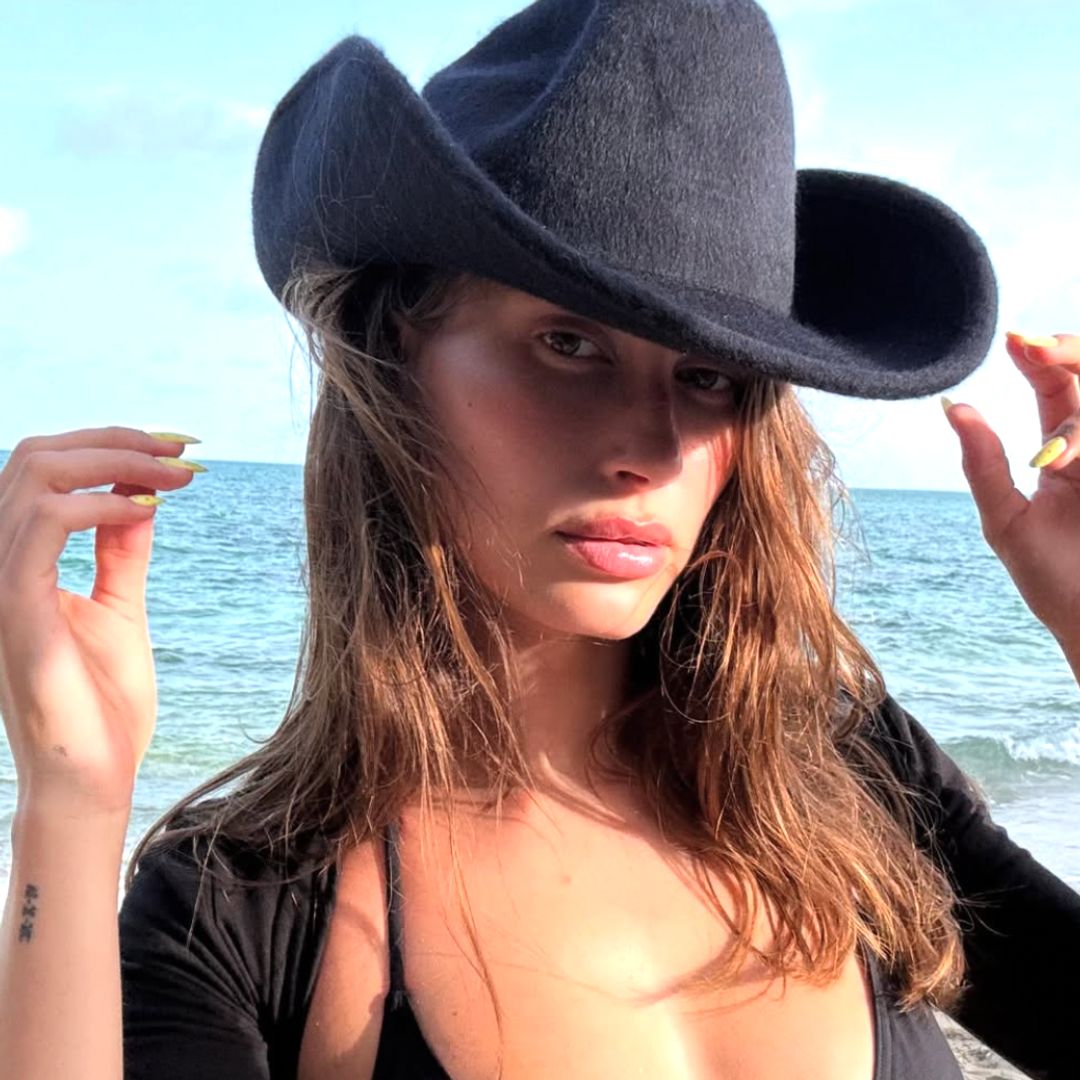 Hailey Bieber black cowboy hat and yellow nails 