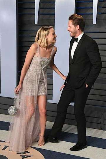 Margot Robbie and Tom Ackerley laughing on the red carpet