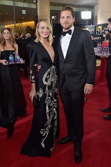 Margot Robbie and Tom Ackerley posing on the red carpet