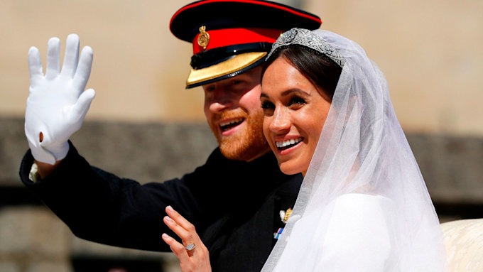 Prince Harry and Meghan Markle smile and wave on their wedding day