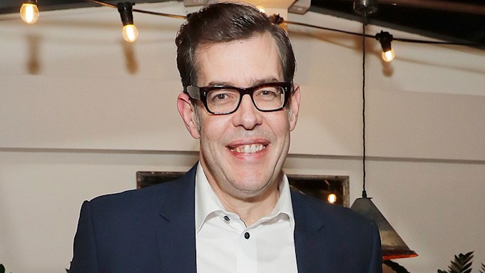 Richard Osman smiling in a suit