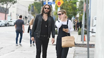 Russell Brand and Laura Gallacher walking on street