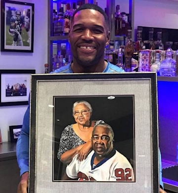 Michael Strahan holds a photo of his parents