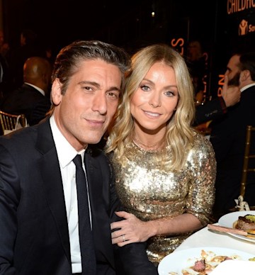 David Muir and Kelly Ripa pose together at a dinner table 